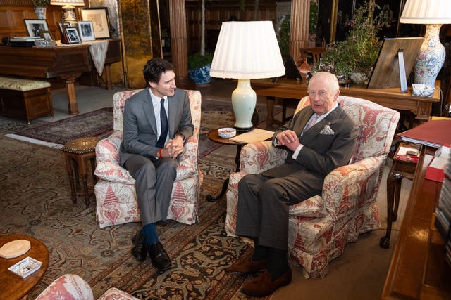 The King sits in comfortable patterned armchairs with Justin Trudeau