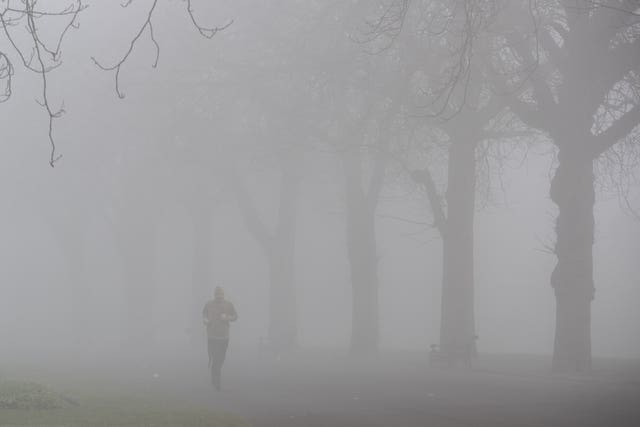 A jogger runs through a foggy Cannon Hill Park in Birmingham (Aaron Chown/PA)