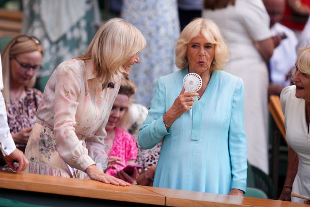 Queen Camilla uses a fan to keep cool in the royal box at Wimbledon