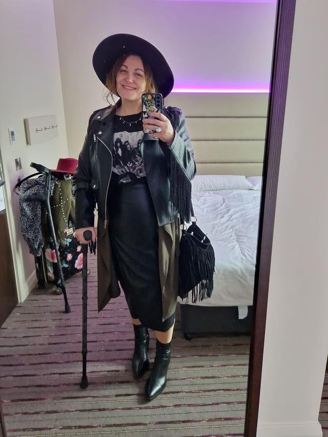 Toni-Claire Miller taking a mirror selfie of herself and standing upright with the id of a walking stick