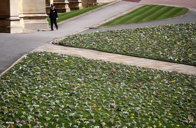 Flowers are laid on the grass outside St George’s Chapel