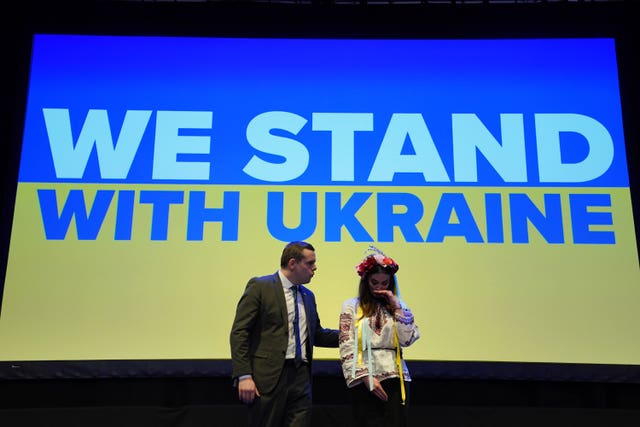 Douglas Ross and Zhenya Dove on stage at Scottish Tory conference in front of a Ukrainian flag that says