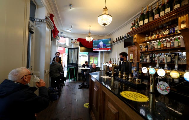 People in the Richmond pub in Liverpool watch a statement by the Prime Minister Boris Johnson (Peter Byrne/PA)