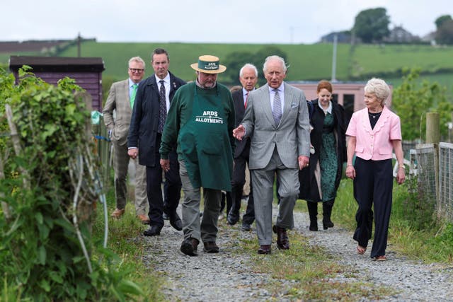 The King walking and talking with Maurice Patton on a track in an allotment
