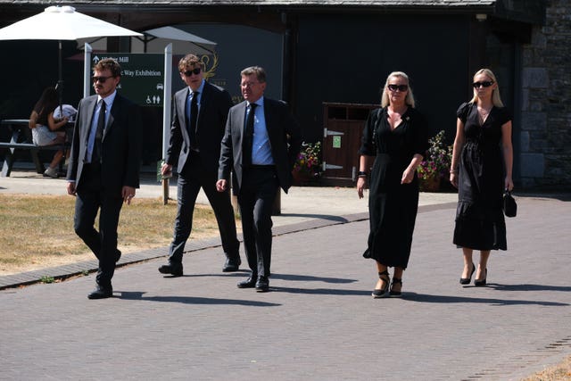 People in dark clothes walking down a street