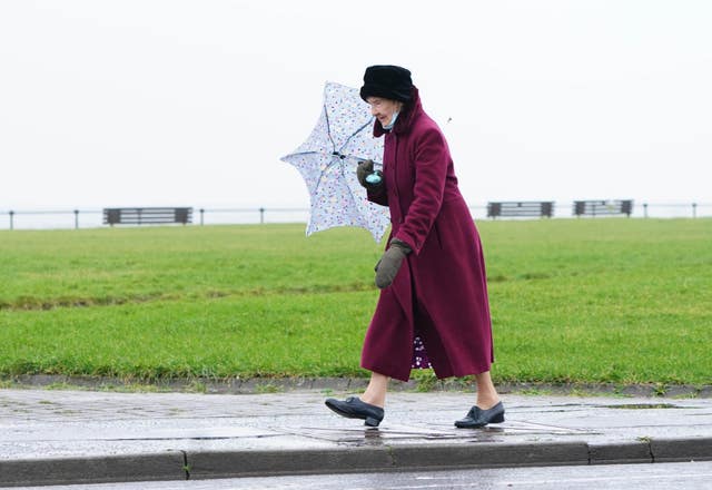 A woman walks along the sea front in Ardrossan in North Ayrshire before Storm Dudley hits the north of England/southern Scotland from Wednesday night into Thursday morning, closely followed by Storm Eunice, which will bring strong winds and the possibility of snow on Friday
