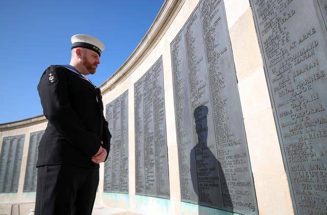 Royal Navy Writer (Submariner) Jamie Martin examines the names on the memorial