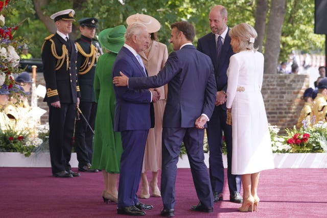 Group of people chatting, Macron has his hand on the king's arm