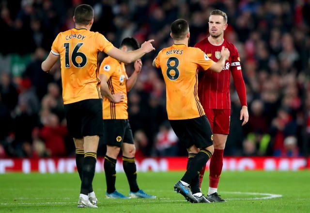 Liverpool’s Jordan Henderson exchanges words with Wolves’ Ruben Neves and Conor Coady