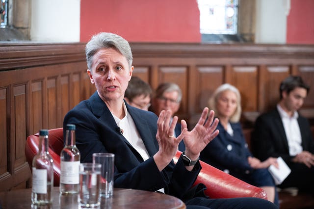 Professor Kathleen Stock speaking while seated in a room full of people