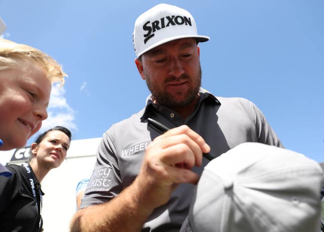 Graeme McDowell signs a hat for a fan
