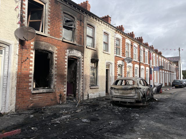 Burned-out cars and houses on Lendrick Street after Tuesday night's disorder width=