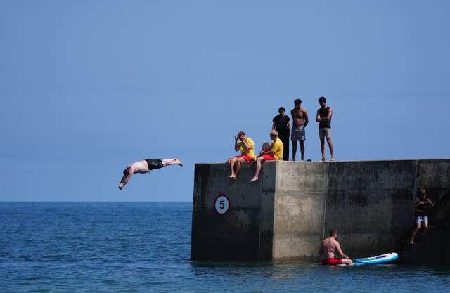 People diving from the seawall at Cullercoats Bay in North Tyneside