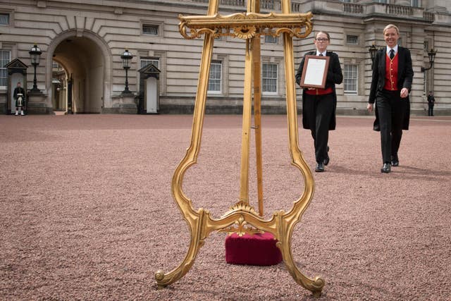 Senior footman Olivia Smith (left) and footman Heather McDonald prepare to place a notice on the easel (Stefan Rousseau/PA)