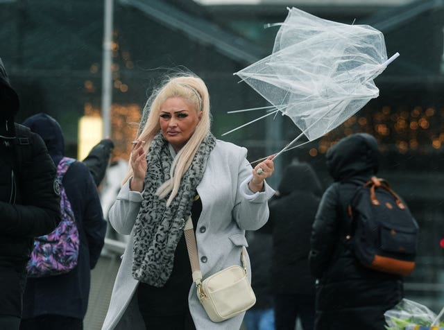 A person holding an umbrella crosses the Sean O’Casey bridge in Dublin