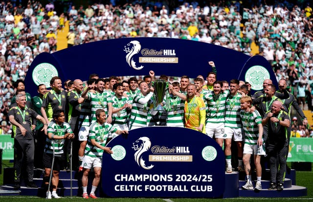 Celtic captain Callum McGregor and James Forrest lift the Premiership trophy surrounded by team-mates