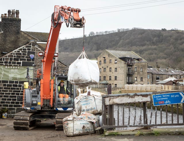 Workers construct flood defences in Mytholmroyd in the Upper Calder Valley, West Yorkshire