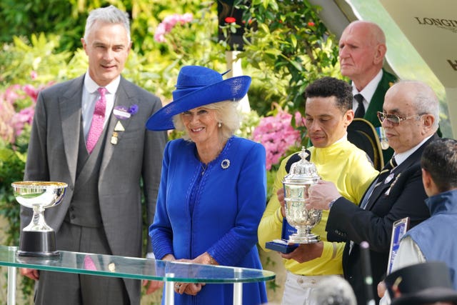 The King and Queen present a trophy to a jockey