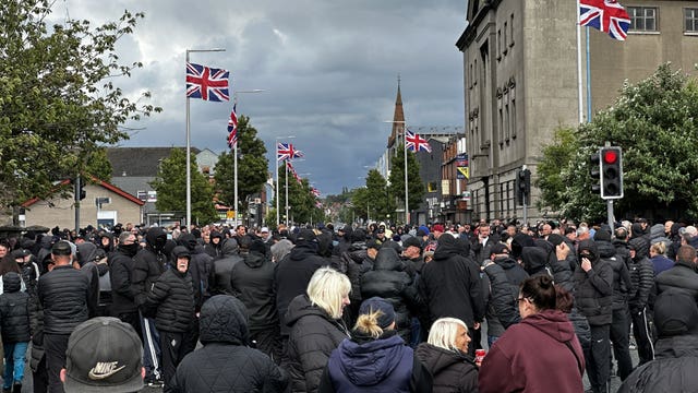 A large group of people, mostly wearing black, on a street