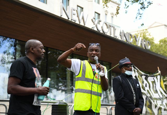 Stafford Scott, centre, speaks outside New Scotland Yard in London