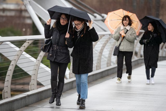 Braving the elements on London's Millennium Bridge