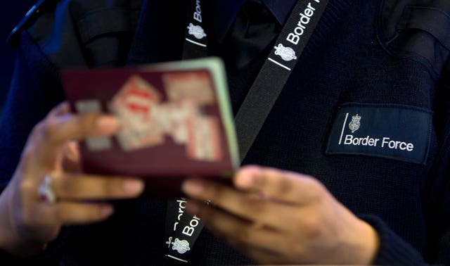 A Border Force officer checks passports at an airport