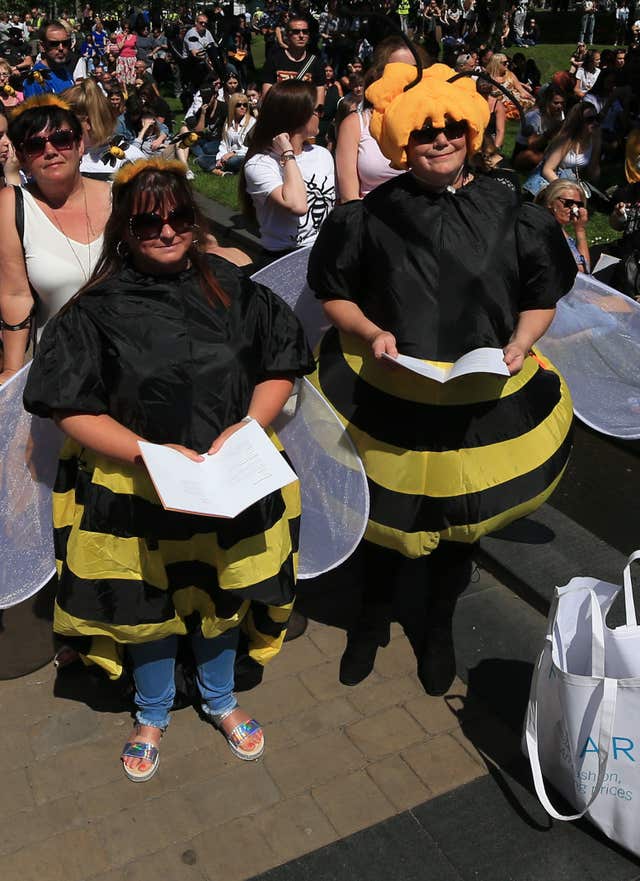 Two women in bee costumes in Cathedral Gardens, as they watch on screen the Manchester Arena National Service of Commemoration (Peter Byrne/PA)