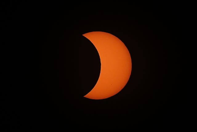 The Moon passes between the Earth and the Sun during the solar eclipse as seen from King’s Stairs Gardens in Bermondsey, south London