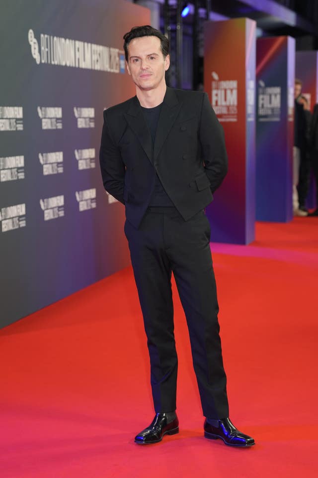 Andrew Scott posing on a red carpet wearing a black suit
