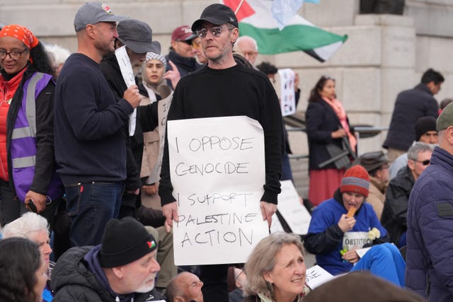 Robert Del Naja holding a sign