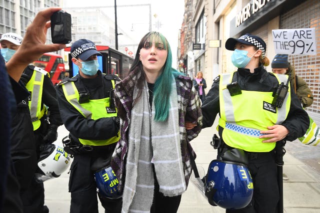 Police detain a woman during an anti-lockdown protest at Oxford Circus