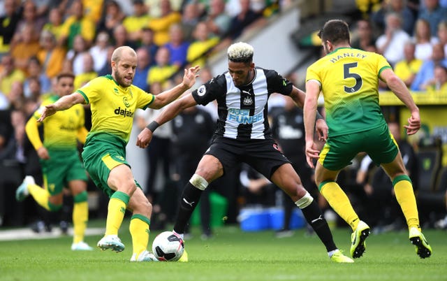 Teemu Pukki (left) and Newcastle’s Joelinton (centre) battle for the ball