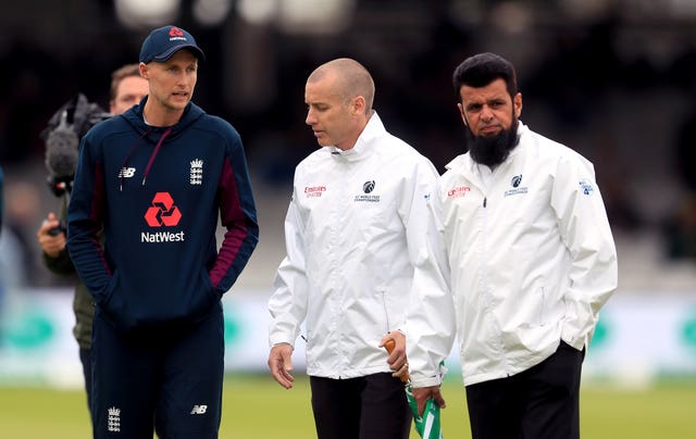 Umpires Aleem Dar and Chris Gaffaney (centre) speak to Joe Root during a pitch inspection