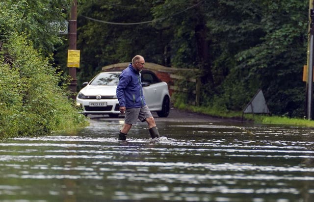 A man wades through a flooded road