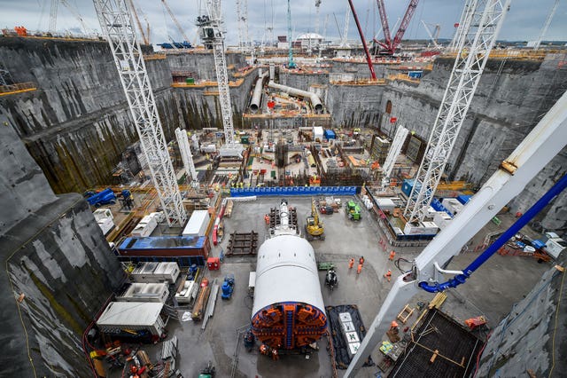 A massive tunnel boring machine in the foreground and huge water cooling pipes sit on the deep dig excavation heat-sink site at Hinkley Point C