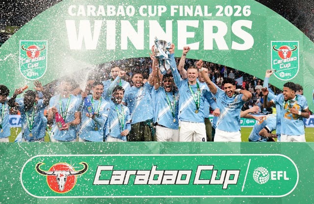 Manchester City’s players celebrate with the trophy after winning the Carabao Cup
