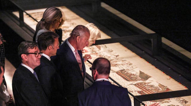 The King, the PM and their guests from France looking at the Bayeux Tapestry