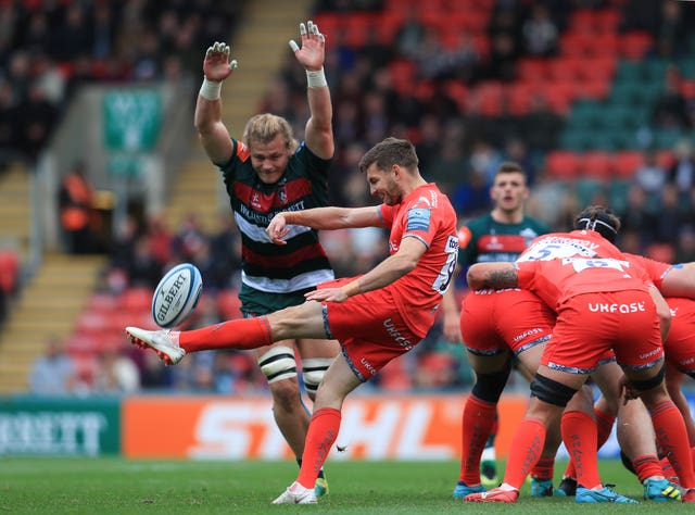 Leicester's David Denton attempts to block a kick from Sale's Will Cliff