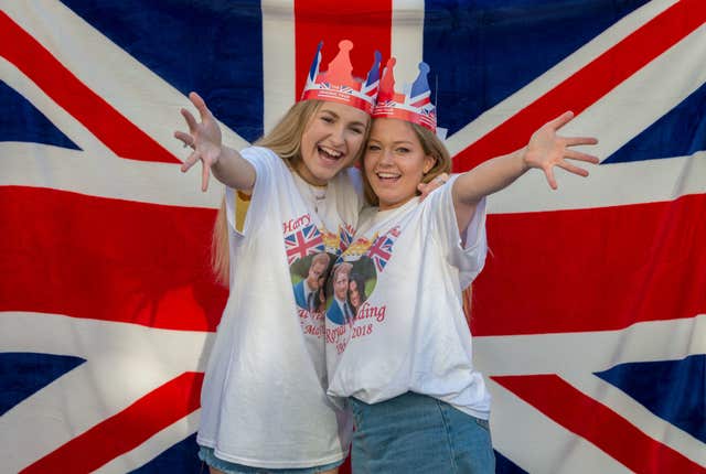Reaching out: teenagers Kitty William and Annabelle West from Mayfair, London wait to cheer on the royal couple (James Hardisty/PA)