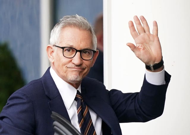 Gary Lineker waves while dressed in a suit and tie