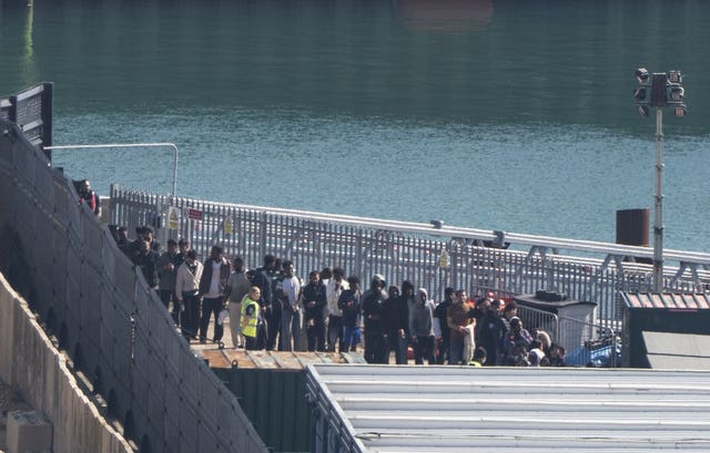 A group of people thought to be migrants are brought in to the Border Security Command compound in Dover, Kent