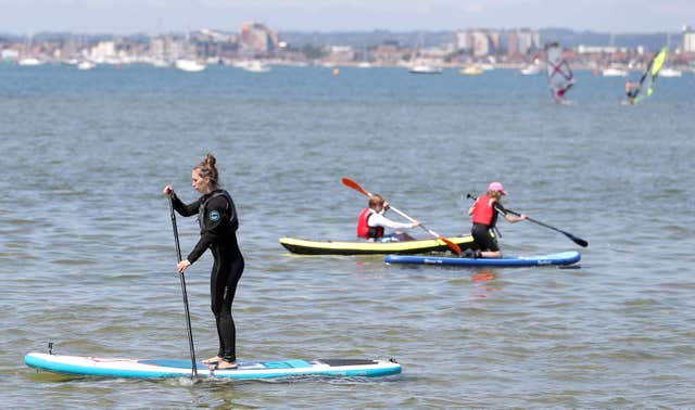 Paddle boarders enjoy the warm weather in Poole Harbour in Dorset