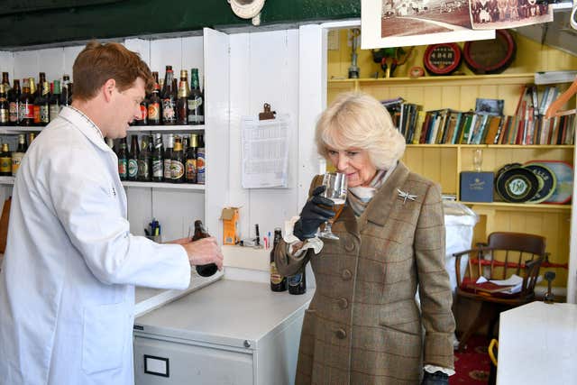 The Duchess of Cornwall smells an Arkell’s Bees Organic Ale before taking a sip (Ben Birchall/PA)
