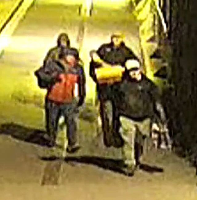 CCTV image of four people walking down a street