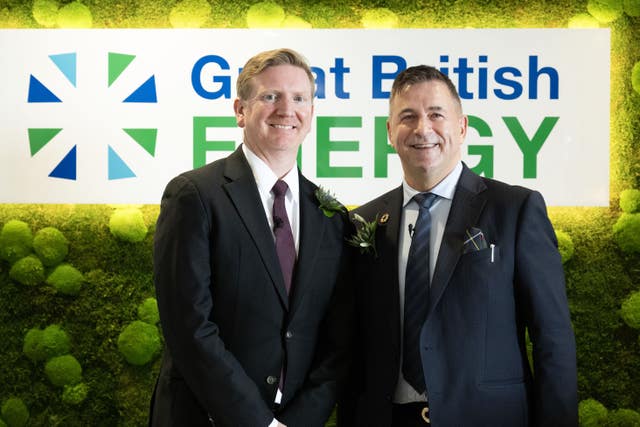 Dan McGrail and Juergen Maier smiling, standing in front of a Great British Energy sign