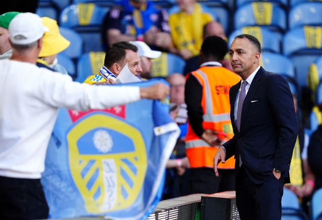 Paraag Marathe stands beside a fan with a Leeds flag