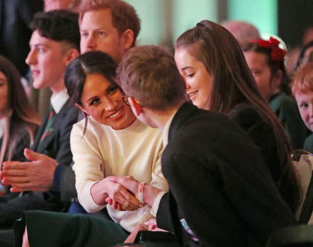 Prince Harry (second left) and Meghan Markle with guests during a visit at the Exhibition Centre in Lisburn