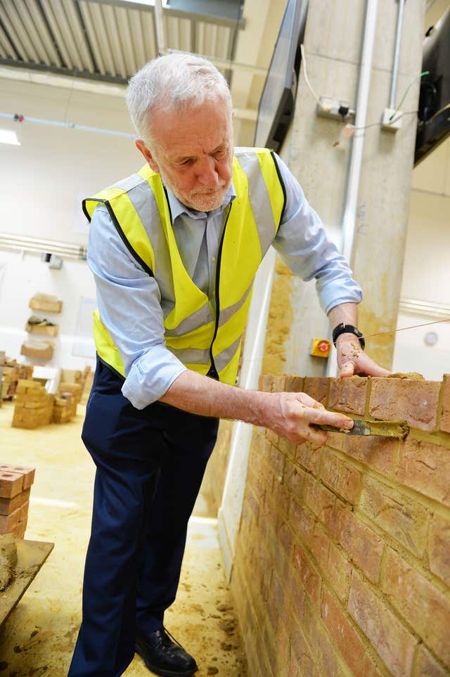 Labour leader Jeremy Corbyn gets hands on with a bricklaying project (John Stillwell/PA)