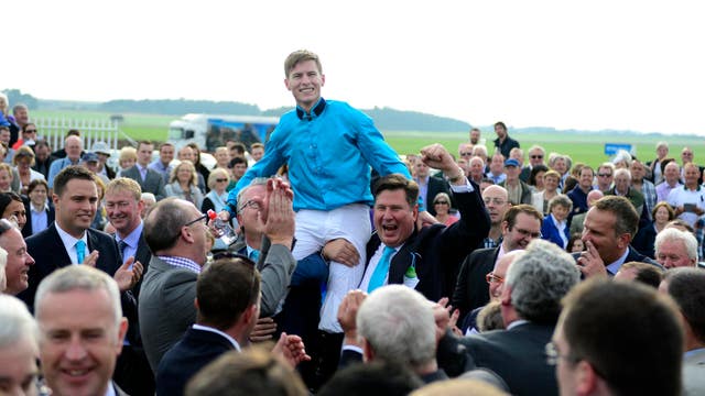 Jockey Richard Kingscote hoisted aloft after Brown Panther's Curragh win