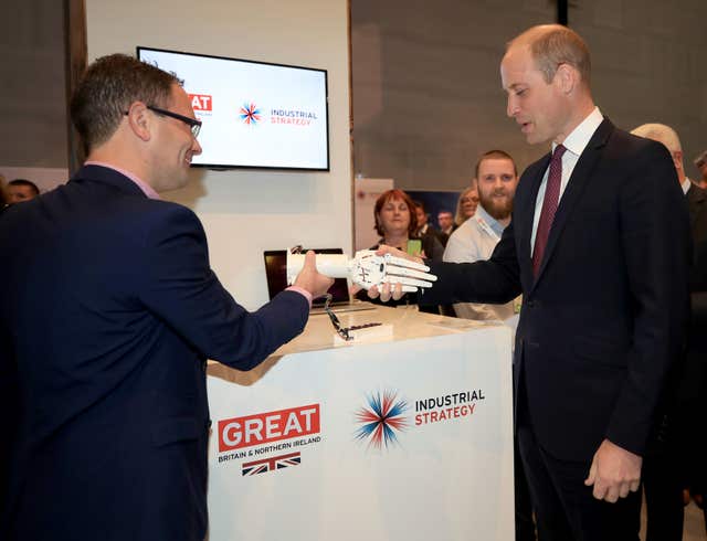 The Duke of Cambridge shakes hands with a robotic hand